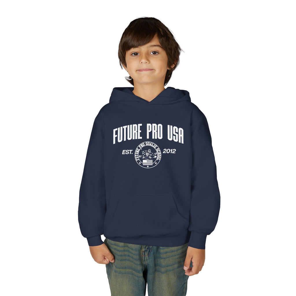 Young male model wearing the youth navy blue Future Pro USA Goalie School hoodie, front view, standing in a casual off-ice setting.